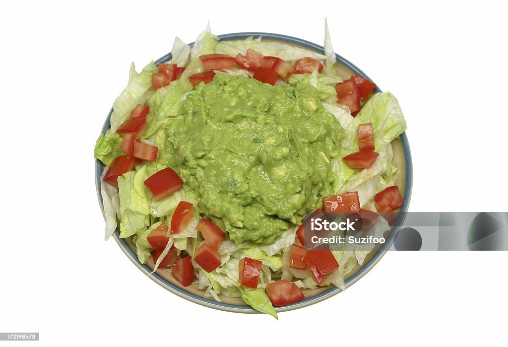guacamole salad A typical appetizer in most any Mexican restaurant - creamy homemade guacamole on chopped iceberg lettuce with diced tomatoes. Isolated on white. Appetizer Stock Photo