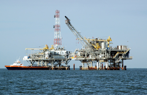 Gas rig with multiple components and crewboat docked. Off the coast of Alabama in the Gulf of Mexico.