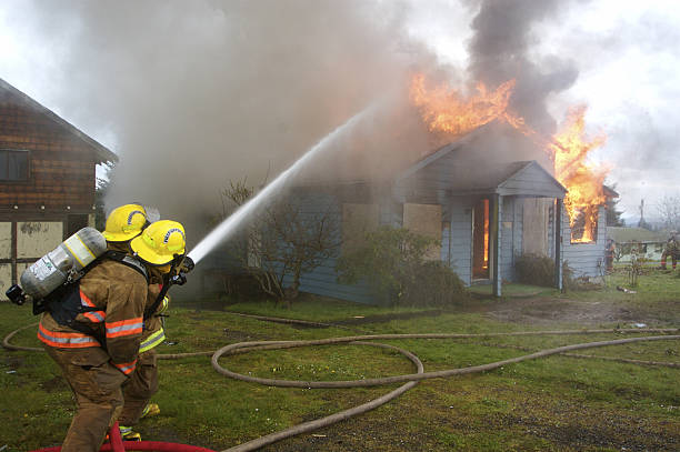 Firefighters Fighting House Fire stock photo