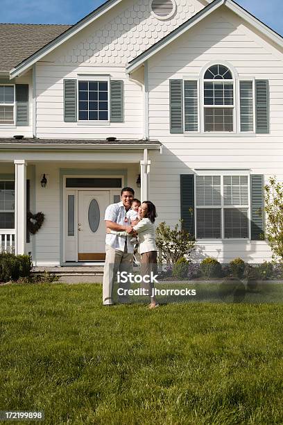 Pequena Família Com Uma Casa Grande Para Preencher - Fotografias de stock e mais imagens de Abraçar - Abraçar, Adulto, Alegria