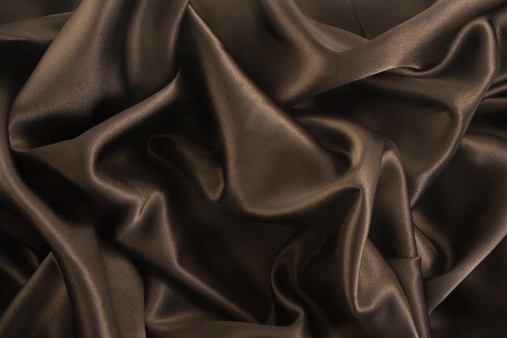 Subject: A background of crumpled luxurious black satin, designed to be used as background for special events, gala parties, and elegant occasions