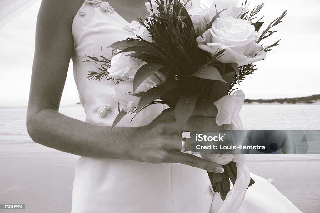 Wedding ring and bouquet Black & white young bride's hand holding white roses bouquet. Adult Stock Photo