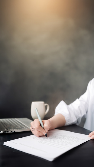 Confident Businesswoman Signing Official Document: Woman's Hand with Pen Finalizing Contract Paper, Demonstrating Professionalism and Commitment in Business, Law, Finance, Notary, Trade, Credit.