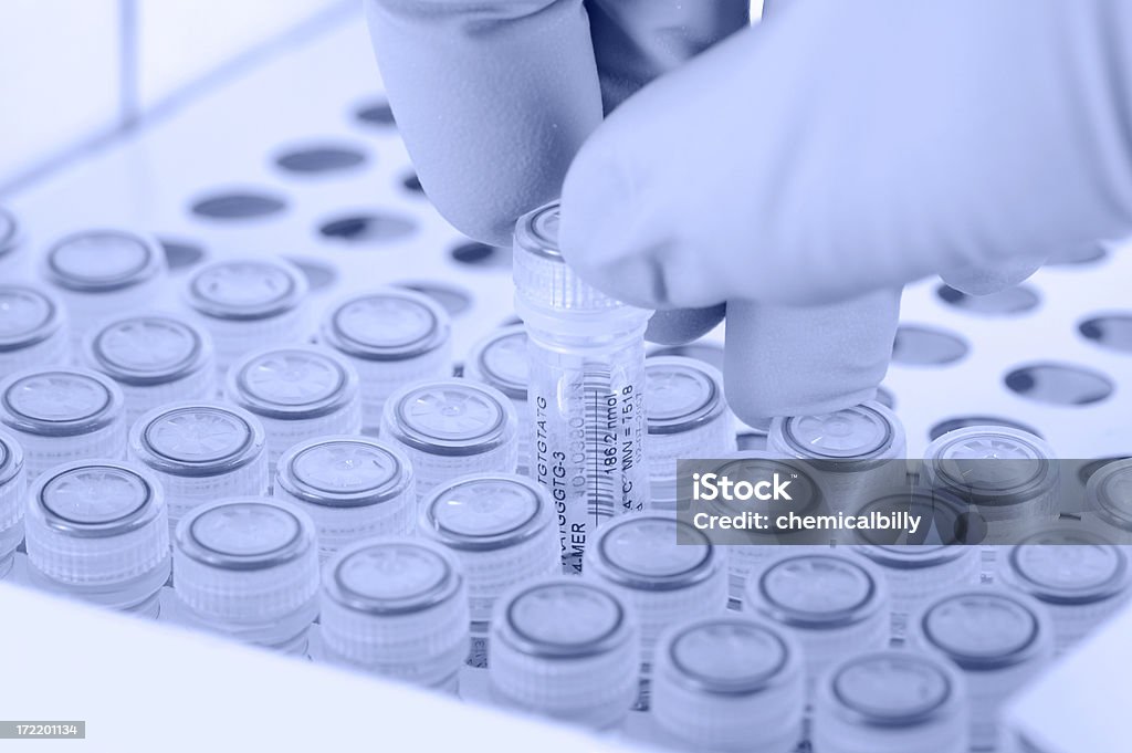 Removing a Tube Scientist removes a tube. Gloved hand. Light blue tint applied to image. Gene Therapy Stock Photo