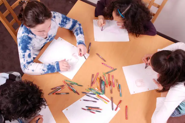 Four kids colour around a table.Shot at the Phillybuster Minilypse.Also available: