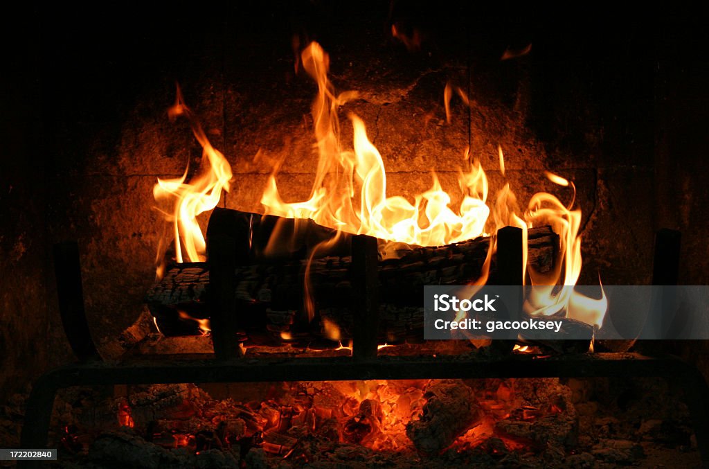 Fire burning in fireplace at night flames dance in fireplace Fireplace Stock Photo