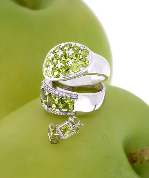 A few pieces of sterling silver jewelry with bead-set peridots in an apple setting