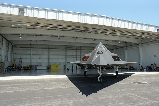 A stealth fighter sits outside a hangar door at Wright Patterson Air Force Base.