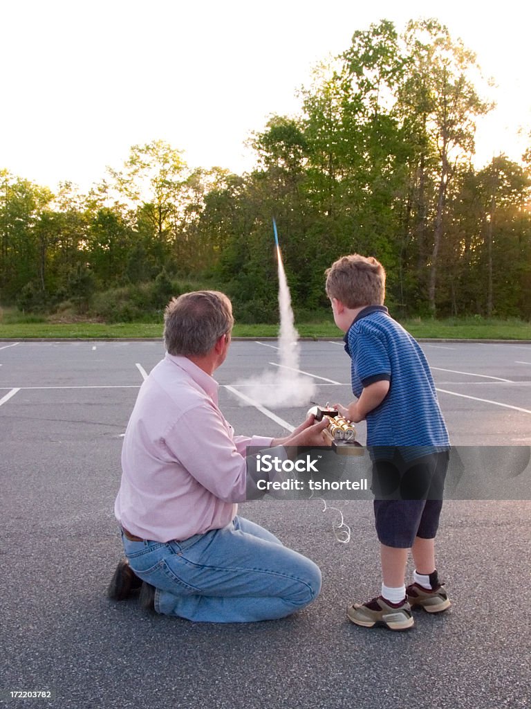 Abuelo y niño lanzar modelo rocket - Foto de stock de Cohete espacial libre de derechos