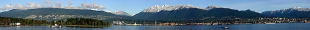 North shore panorama of the Burrard inlet "A panorama of the north shore of the Burrard inlet, on a clear autumn day with fresh snow on the mountain's peaks. Includes part of Stanley park with the Lions Gate bridge and the cities of West Vancouver and North Vancouver." west vancouver stock pictures, royalty-free photos & images