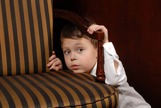少年の後ろに隠した椅子 - shy child little boys hiding ストックフォトと画像