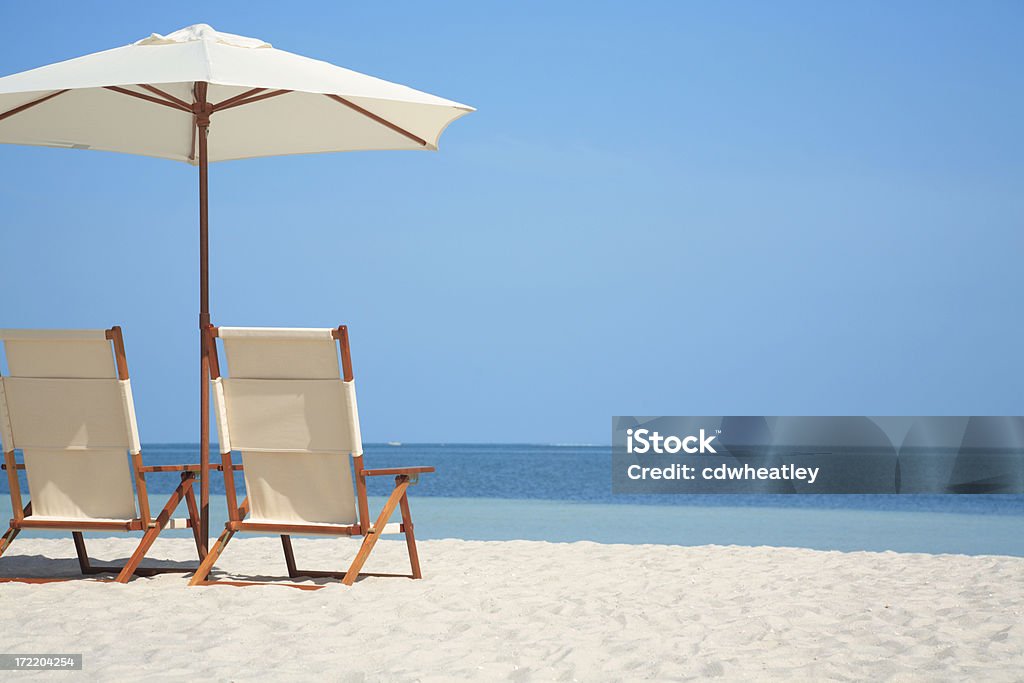 Vazio cadeiras e guarda-chuva em uma praia na Flórida, EUA - Foto de stock de Cadeira de Praia royalty-free
