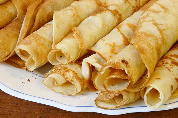 Fresh sweet pancakes rolled up on plate
