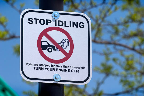 A sign on a post saying stop idling stock photo