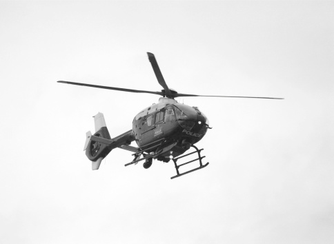 A police helicopter in flight in black and white