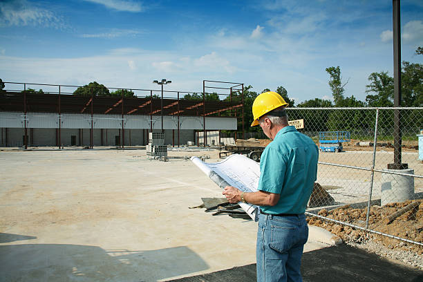 istock Supervisor man wearing hardhat and holding blueprints at construction site. 172204755