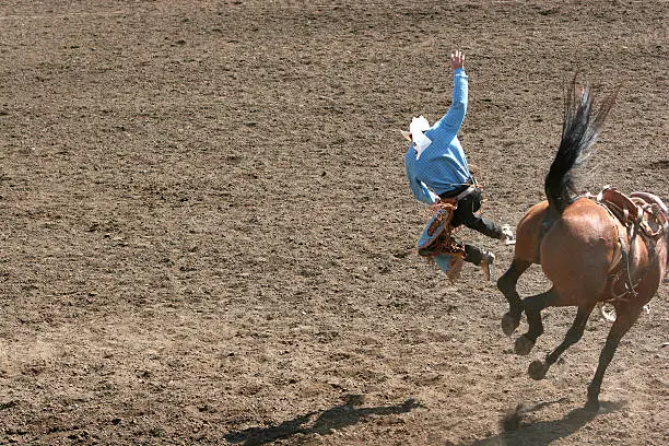 Cowboy was bucked off the horse at the rodeo.