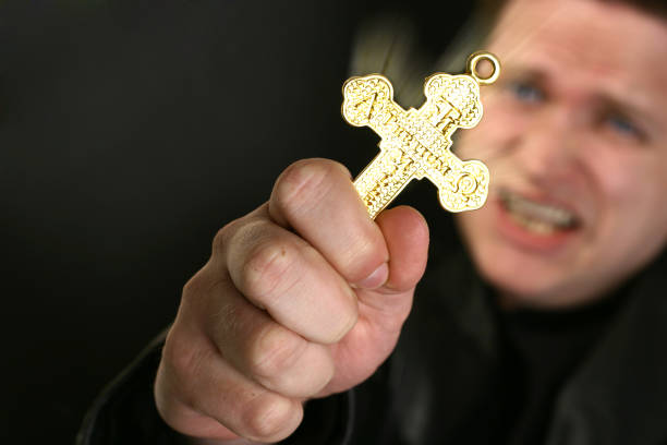 Crucifix Picture of a man holding a crucifix.  There is latin words on the cross and Christian symbols. You can find more photographs of this model in exorcism stock pictures, royalty-free photos & images