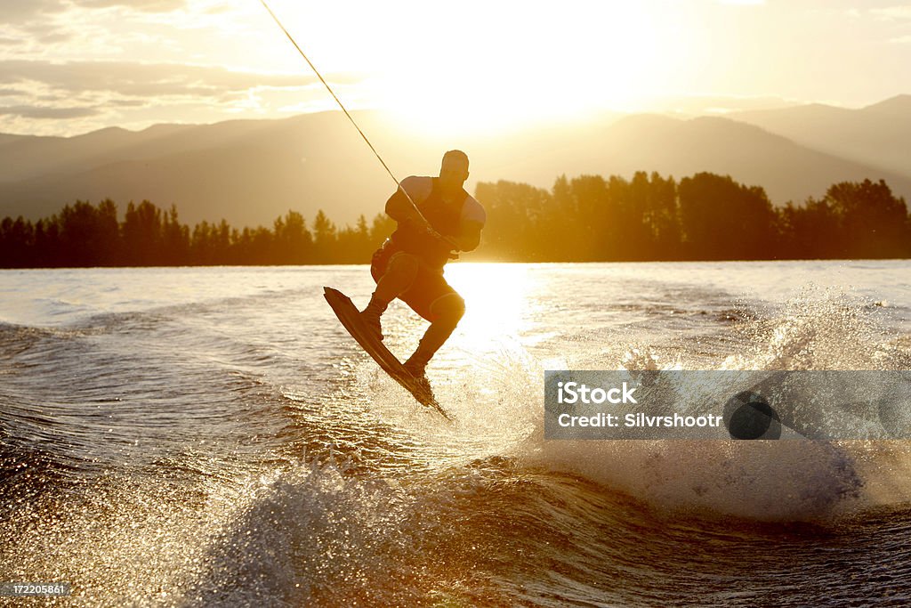 wakeboarder at sunrise "A wakeboarder catches air during a sunrise session on Lake Pend Oreille, near Sandpoint, Idaho" Wakeboarding Stock Photo