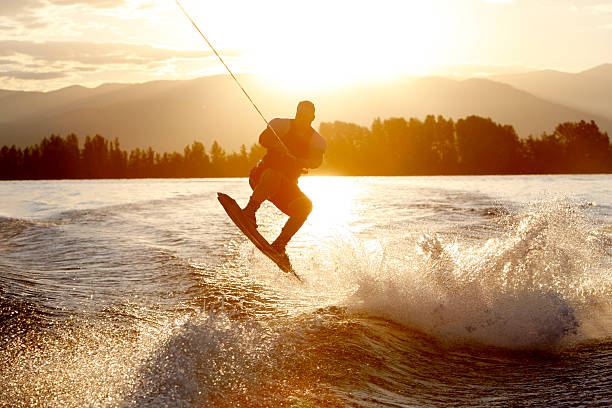 wakeboarder na wschód słońca - wakeboarding waterskiing water sport stunt zdjęcia i obrazy z banku zdjęć