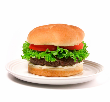 One stacked to order juicy all beef hamburger on a bun with lettuce and tomato.