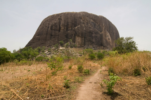 Zuma Rock, a large monolith in Niger state close to Abuja. A face can be seen eroded in the rock at about a quarter of the rock from the right.