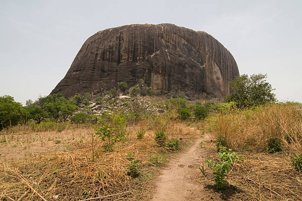 The way to Zuma Rock Zuma Rock, a large monolith in Niger state close to Abuja. A face can be seen eroded in the rock at about a quarter of the rock from the right. abuja stock pictures, royalty-free photos & images