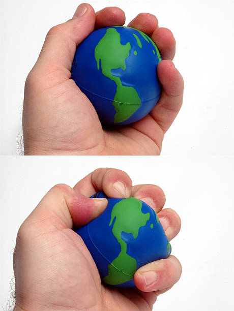 weltweiten dominanz - crushed human hand earth ball stock-fotos und bilder
