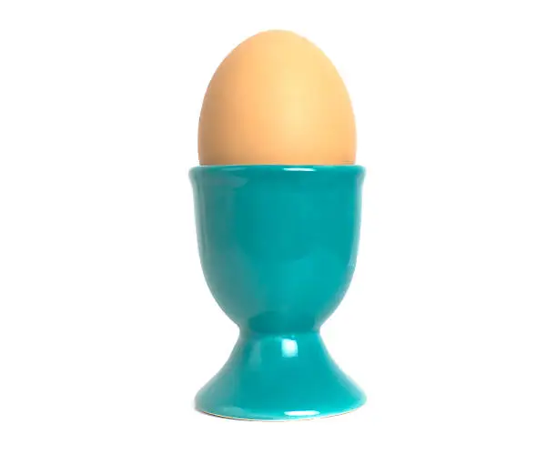 A cyan blue eggcup with a brown hen's egg.Eggcups: