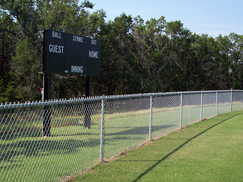 Baseball field fence and scoreboard.