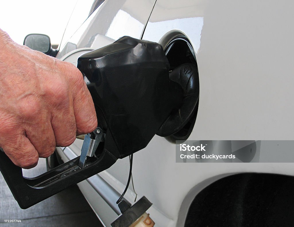 Pumping Gas Man pumping gas into a minivan. Mini Van Stock Photo