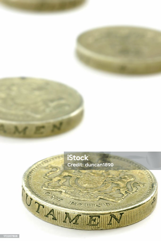 Coins UK Pounds Some UK pounds coins. (Narrow focus on the frount of the fist coin, on the words 'one pound') Abundance Stock Photo