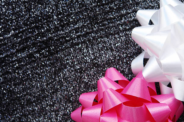 Pink and white bow on sparkling fabric stock photo