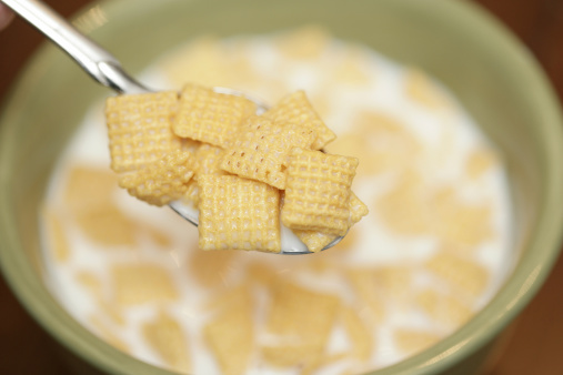 high res image of someone eating cereal (corn chex)