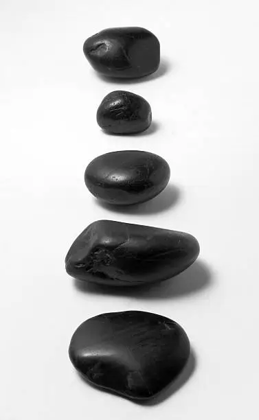 line of massage stones on white backgroundrelated images