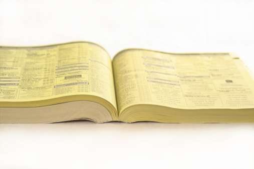 Shallow DOF photo of yellow pages on isolated background.