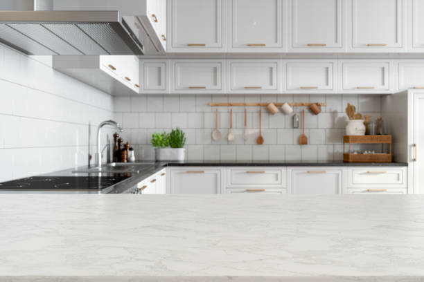 Empty White Marble Countertop With Blurred Kitchen Background Empty White Marble Countertop With Blurred Kitchen Background kitchen island stock pictures, royalty-free photos & images