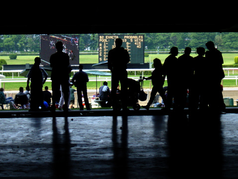 silhouetted people at Belmont Park races nyc