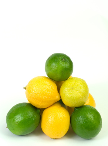 Lemons and limes stacked on white with clipping path.