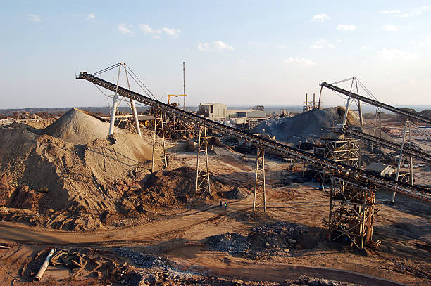 Stockpiles at Sundown "Conveyor belts feed broken rock into two different stockpiles (oxides and sulphides) at an open-pit copper mine in Zambia, Africa." copper mine stock pictures, royalty-free photos & images