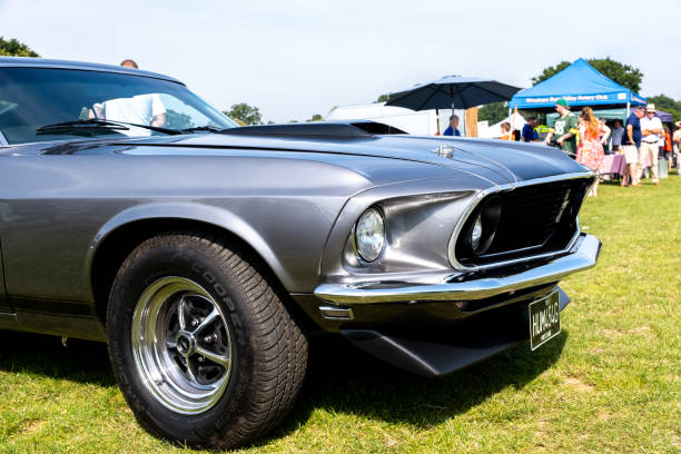 Wroxham, Norfolk, UK  September 10 2023. Front end shot of the bonnet, headlights, grille, bumper and tyre of a 1969 Ford Mustang muscle car on display at an outdoor car show