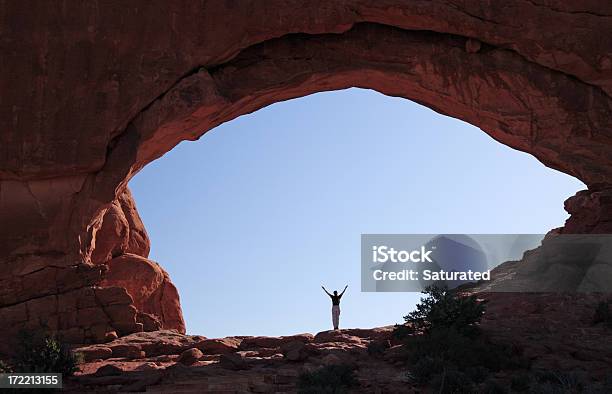 Mujer Con Los Brazos Estirados En Rock Arch Foto de stock y más banco de imágenes de Adulto - Adulto, Aislado, Alegría