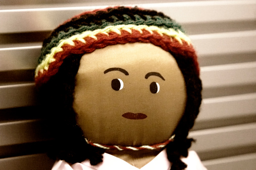 an old Jamaican rag doll. focus is only on eyes and photo is grainy.