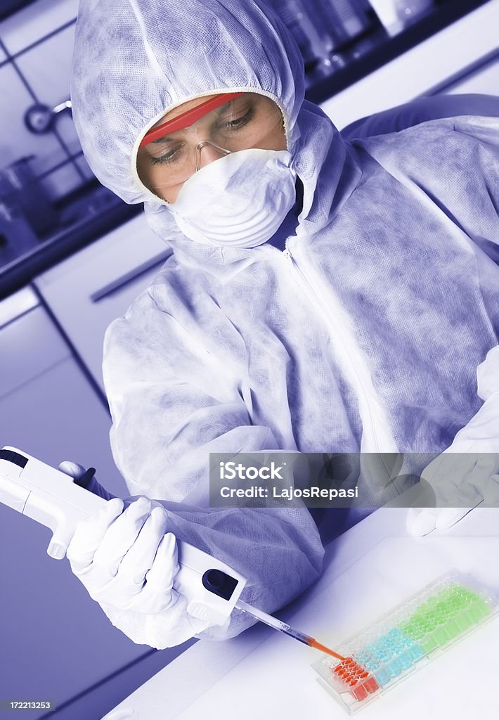 Giovane donna che lavora con la pipetta in laboratorio - Foto stock royalty-free di Adulto