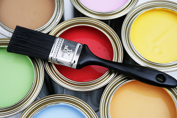 istock Paint brush resting on open paint buckets 172213938