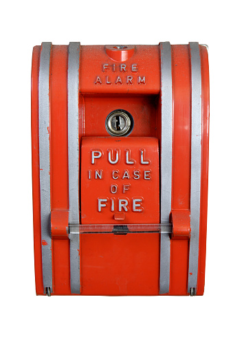 An old, dirty fire alarm, isolated on white background. (Clipping path included.)