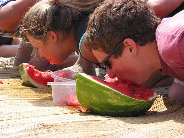 Children eating watermelon at the beach
