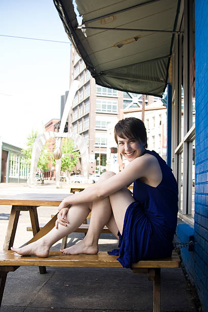 jeune femme assise à l'extérieur du bâtiment urbain - love smiling human settlement viewpoint photos et images de collection