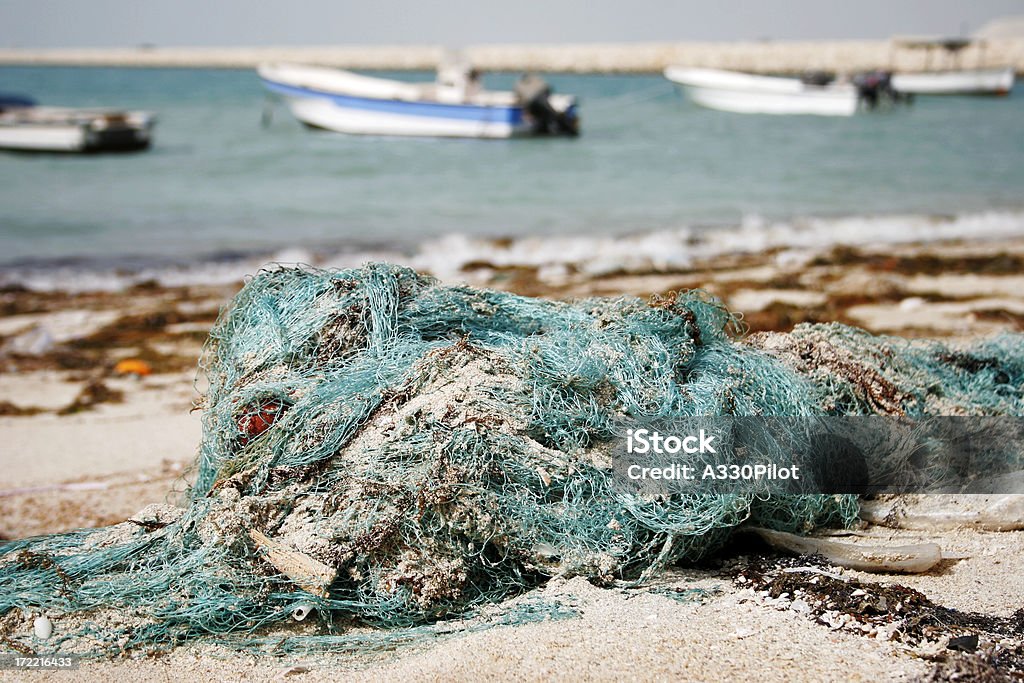 Abondoned Fishing Nets Old fishing nets polluting the shoreline. Fishing Industry Stock Photo