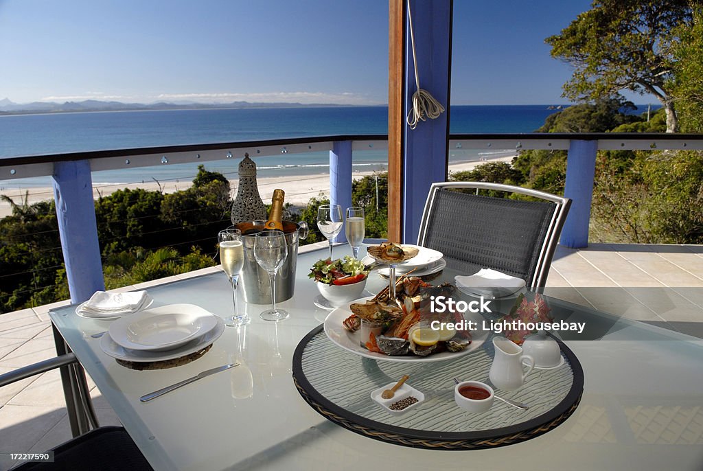 Ustawienie elegancki kolację z owoców morza dla dwóch osób z widokiem na Byron Bay - Zbiór zdjęć royalty-free (Dzielnica nadbrzeżna)